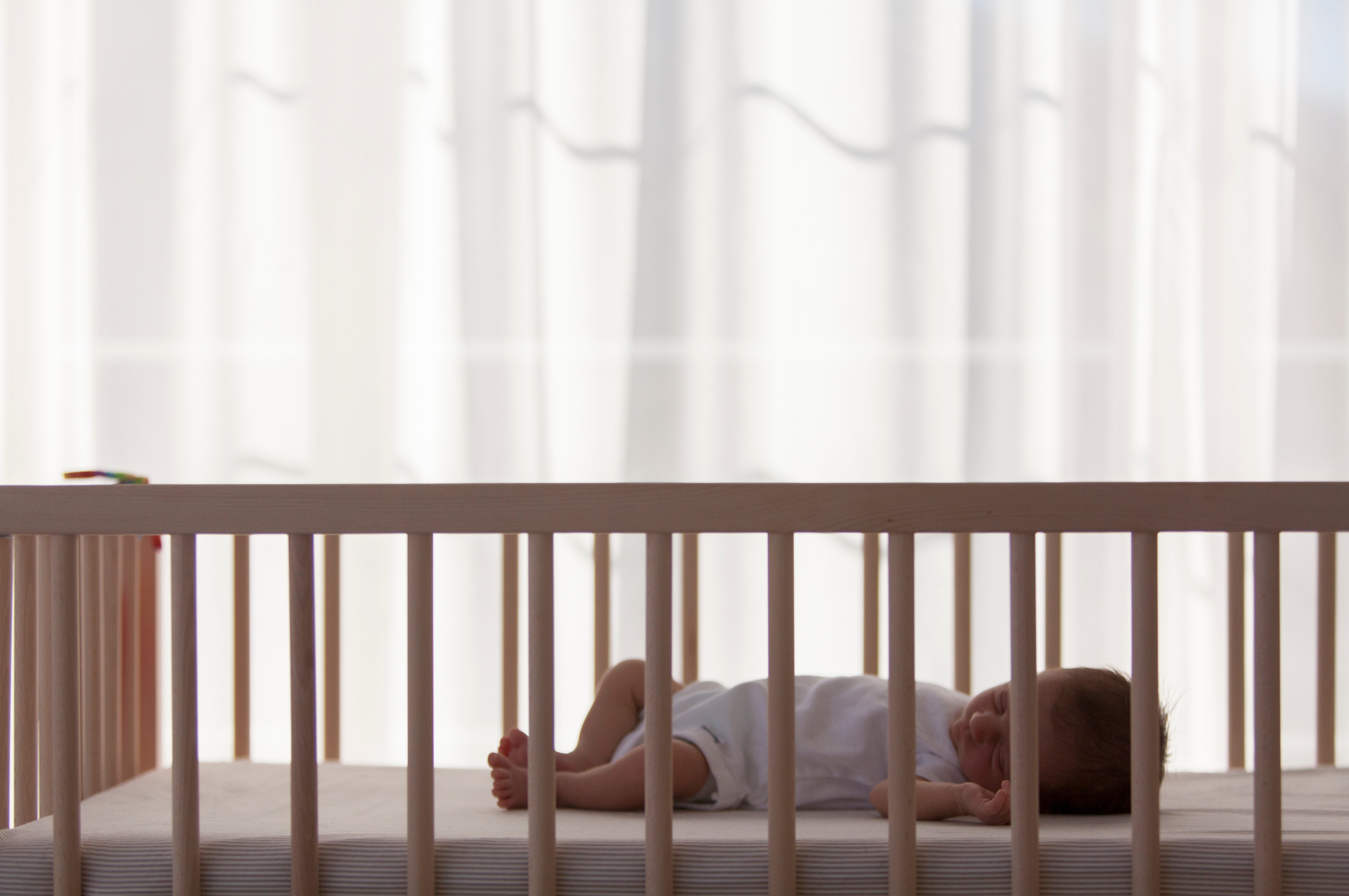 Baby resting in a crib viewed from above